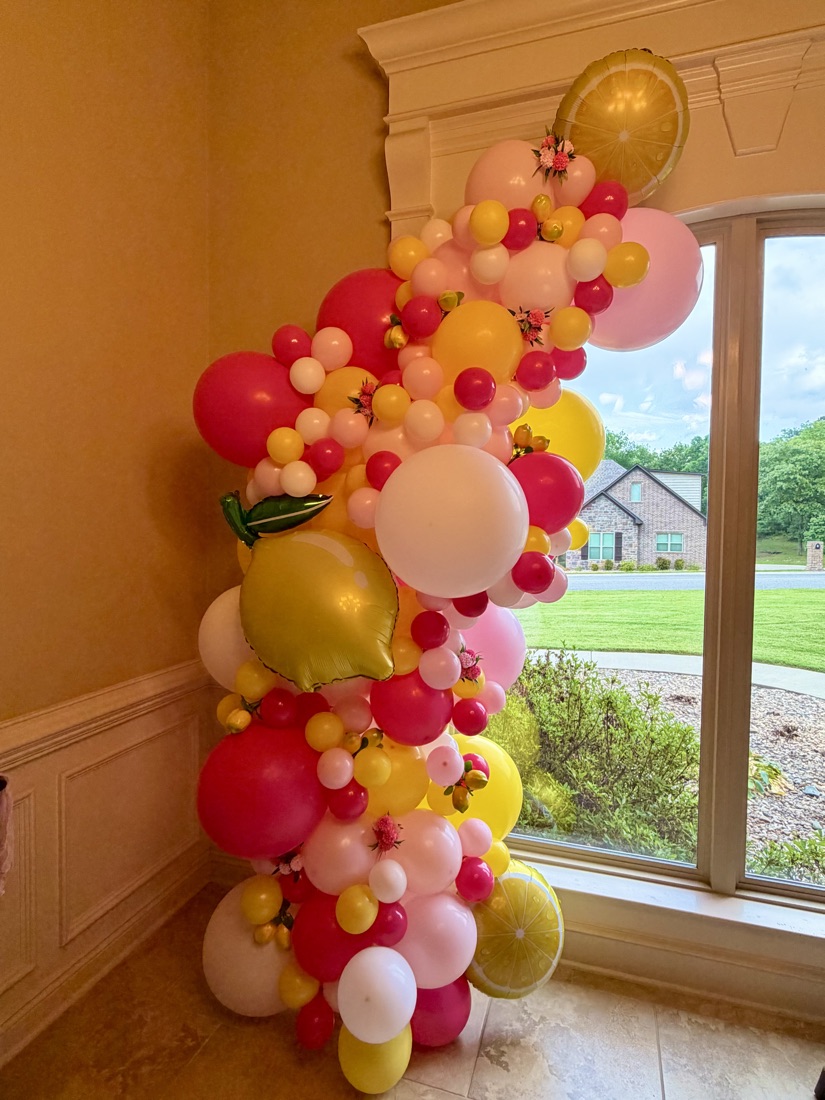 Lemonade-themed balloon garland by a window